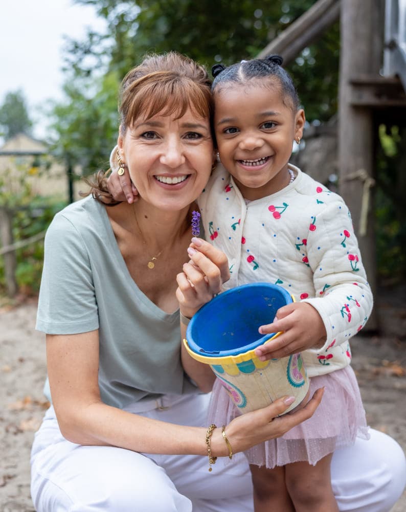 Kind speelt buiten met pedagogisch medewerker bij kinderopvang Kind&co ludens