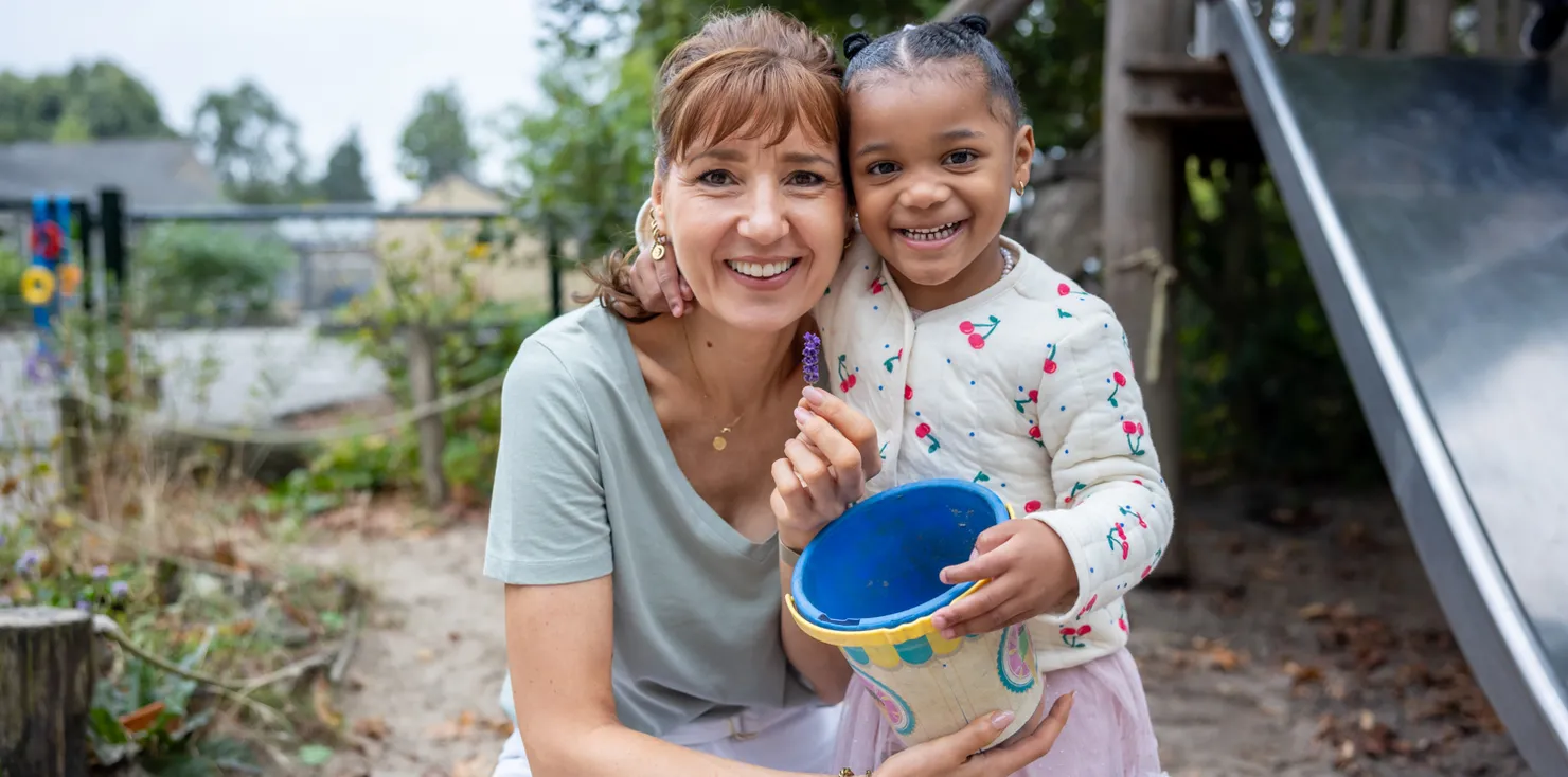 Kind speelt buiten met pedagogisch medewerker bij kinderopvang Kind&co ludens