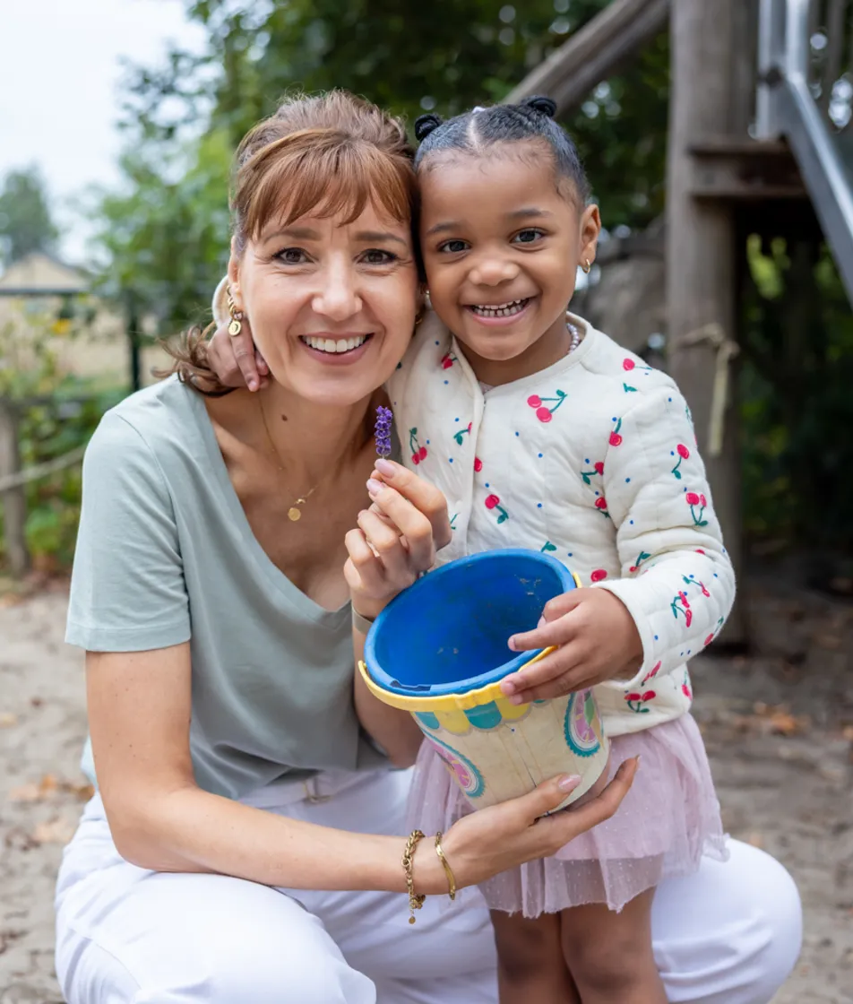Kind speelt buiten met pedagogisch medewerker bij kinderopvang Kind&co ludens